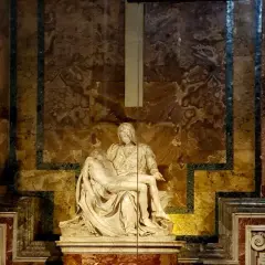Pieta Michała Anioła, marmurowa rzeźba przedstawiająca Matkę Boską trzymającą ciało Chrystusa, w otoczeniu bogato zdobionej ściany.
