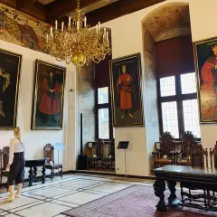 Wielka sala z portretami królów i bogatym żyrandolem. Sprawdź muzeum narodowe w gdańsku godziny otwarcia, by zobaczyć to na żywo.