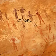 Prehistoryczne malarstwo jaskiniowe ukazuje grupę postaci ludzkich w ruchu, być może podczas rytuału lub polowania.