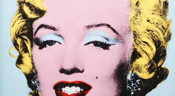 Ikona popkultury w stylu Andy'ego Warhola. Marilyn Monroe z żółtymi włosami, różową cerą i wyrazistymi ustami.