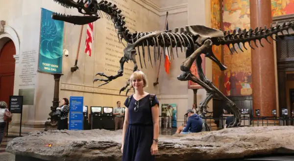 Kobieta pozuje przed szkieletem dinozaura w jednym z muzeów Nowego Jorku.