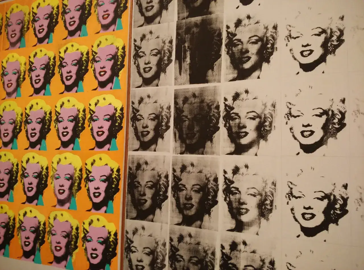 Ikony Marilyn Monroe w żywych kolorach i czarno-białych wersjach, ikoniczny przykład ruchu artystycznego Andy'ego Warhola.