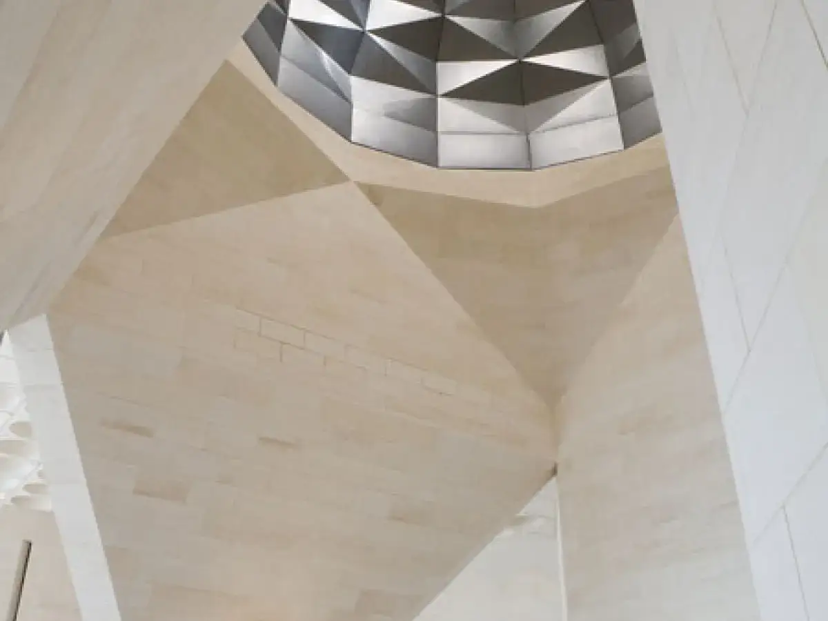 Geometryczne sklepienie w muzeum sztuki islamskiej, z kamiennymi panelami i metalową kopułą.