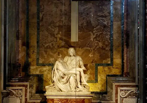 Pieta Michała Anioła, marmurowa rzeźba przedstawiająca Matkę Boską trzymającą ciało Chrystusa, w otoczeniu bogato zdobionej ściany.