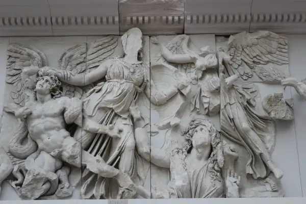 Antyczne rzeźby, jak ten fragment fryzu z Pergamonu, ukazują dynamiczne sceny walki. Widać tu skrzydlate postacie i walczących ludzi, co stanowi wspaniałe przykłady rzeźby antycznej.